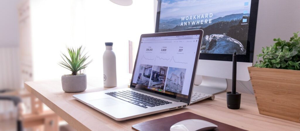 MacBook Pro on table beside white iMac and Magic Mouse